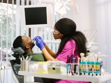 man with dental assistant looking at smile